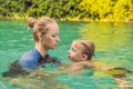 Woman swimming instructor for children is teaching a happy boy to swim in the pool Royalty Free Stock Photo