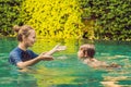 Woman swimming instructor for children is teaching a happy boy to swim in the pool Royalty Free Stock Photo