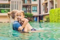 Woman swimming instructor for children is teaching a happy boy to swim in the pool Royalty Free Stock Photo