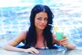 Woman in swimming pool with cocktail Royalty Free Stock Photo