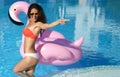 Woman in a swimming pool leisure on a giant inflatable giant pink flamingo float mattress in red bikini Royalty Free Stock Photo