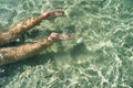 Woman swimming on the sea. Female legs under clear sea water. Realistic top view photo of a women's legs barefoot. Royalty Free Stock Photo