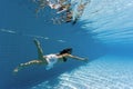 Woman swimming underwater in a pool