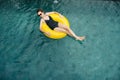 Woman swimming on a yellow buoy, relaxing and enjoying her life Royalty Free Stock Photo