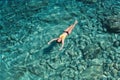 A woman swims in blue sea water in the bay. Nature and relaxation, top view Royalty Free Stock Photo