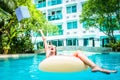 Woman swims in the swimming pool in the pool and throws the laptop into the water. The girl is resting on the sea on an