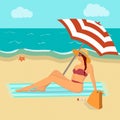 A woman in a swimsuit sits under an umbrella on the beach. Woman sunbathes on the beach.Beach background