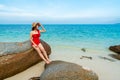 Woman in swimsuit sitting on stone beach with sea at Koh MunNork Island, Rayong, Thailand Royalty Free Stock Photo