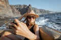 Relaxed woman sailing on the yacht near the rocky coast Royalty Free Stock Photo