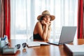 Woman at table in office thinking about voyage