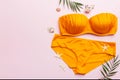 Woman swimwear and beach accessories flat lay top view on colored background Summer travel concept. bikini swimsuit, straw hat and Royalty Free Stock Photo