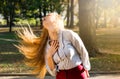Woman swinging hair in the park, healthy hair concept