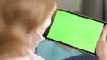 Woman swiping and scrolling green screen page on digital tablet, video embed mockup