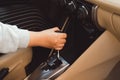Woman switches the automatic transmission`s close-up. Close-up of the driver`s adm includes mode Drive on the gear lever automat Royalty Free Stock Photo