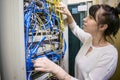 Woman switches the wires in the patch panel. The specialist works in the server room of the data center. The girl is checking the Royalty Free Stock Photo