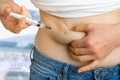 Diabetic woman with syringe inject insulin to her belly Royalty Free Stock Photo