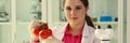 A woman at the table in the laboratory holds tomatoes Royalty Free Stock Photo