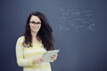 Woman with tablet in front of background with drawn business chart and icons. Royalty Free Stock Photo