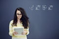 Woman with tablet in front of background with drawn business chart and icons. Royalty Free Stock Photo