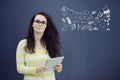 Woman with tablet in front of background with drawn business chart and icons. Royalty Free Stock Photo