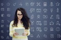 Woman with tablet in front of background with drawn business chart and icons. Royalty Free Stock Photo