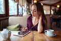 Woman with tablet pc using internet in restaurant.