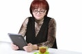 Woman with a tablet at the table on a white background.