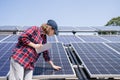 Woman with tablet touching solar panel