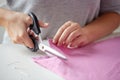 Woman with tailor scissors cutting out fabric