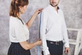 Woman tailor takes measures with male models. Fashion designer s