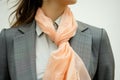 woman in a tailored suit, accessorizing with a peach silk scarf Royalty Free Stock Photo