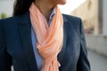 woman in a tailored suit, accessorizing with a peach silk scarf Royalty Free Stock Photo