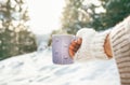 Woman take in hand cup of hot drink. Winter forest glade, bright