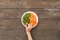 Woman take some carrots and beans lie on a plate