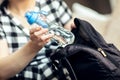 Woman takes the bottle out from backpack