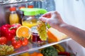 Woman takes the bunch of grapes from the open refrigerator Royalty Free Stock Photo