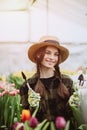 A woman takes care of tulips flowers in the garden. Spring and summer. happy woman gardener with flowers. Greenhouse flowers. Real