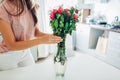 Woman takes dead dry bouquet of roses flowers out of vase. Housewife taking care of coziness on kitchen Royalty Free Stock Photo