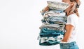 Woman takes in hands big pile blue and beige blankets, towels an