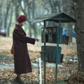 A woman takes a letter out of an old mailbox outdoor. Royalty Free Stock Photo