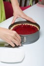 The woman takes Levington`s cake out of the mold. A cake decorated with raspberries Royalty Free Stock Photo