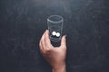 Woman takes medicines with glass of water chalk drawn on blackboard. Close up of woman hand taking in pill in drawn water glass. Royalty Free Stock Photo