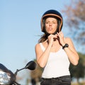 Woman takes off helmet on scooter