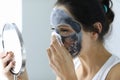 Woman takes off her anti-aging face mask Royalty Free Stock Photo