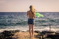 Woman takes off her clothes in the wind while standing on the beach against the backdrop of a waving the sea Royalty Free Stock Photo
