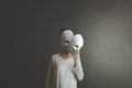 Woman takes off the mask from her face but underneath her she has another mask, concept of hiding one`s soul and oneself Royalty Free Stock Photo