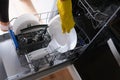 A woman takes out clean dishes from the dishwasher Royalty Free Stock Photo