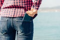 Woman takes out smartphone of her rear pocket of jeans