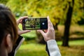 A woman takes a photo of a beautiful autumn landscape using her phone Royalty Free Stock Photo