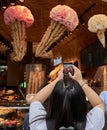 Woman takes photo with cell phone of a clever Ice cream advertising display at a Munich Ice Cream Parlour.